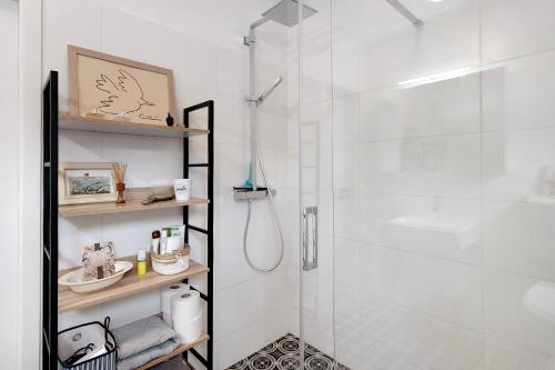 a white bathroom with a shower with a glass door at Apartment Dreiländer Blick in Wintersweiler