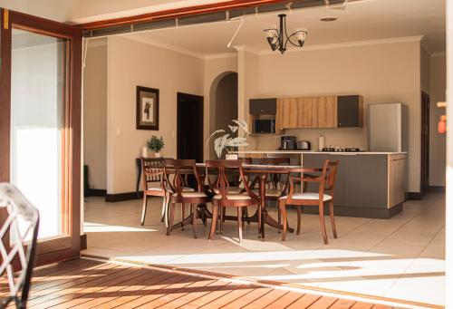 a kitchen and dining room with a table and chairs at Peaceful Home In Richmond Hill in Gqeberha