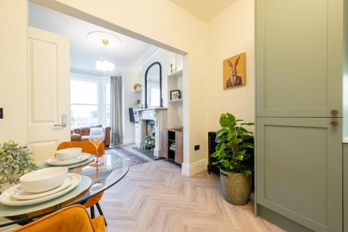 a dining room with a table and chairs and a living room at Battersea Boutique Apartments in Bangor