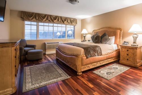 a bedroom with a bed and a chair and a window at Riverside Hotel, an Ascend Collection Hotel in West Chesterfield