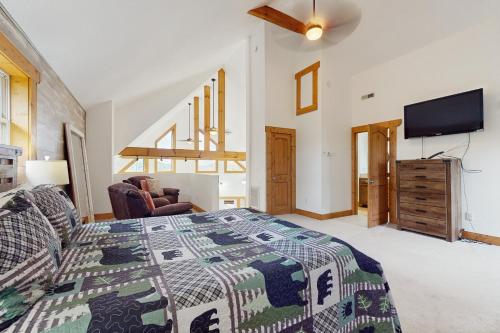 a bedroom with a bed and a flat screen tv at Woodland Chalet in Boyds Creek