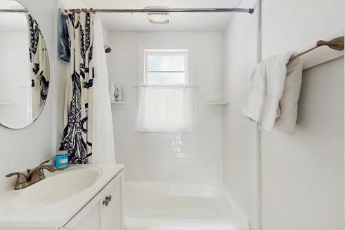 ein weißes Badezimmer mit Waschbecken und Badewanne in der Unterkunft The Kettle Cottage in Cotuit