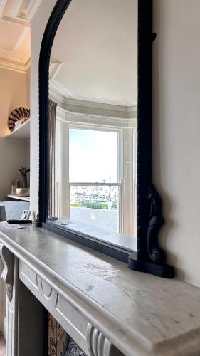 a mirror sitting on top of a fireplace at Battersea Boutique Apartment 1 in Bangor