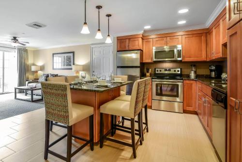 a kitchen with wooden cabinets and a island with chairs at Bluegreen Vacations South Mountain, an Ascend Collection Resort in Lincoln