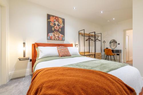 a bedroom with a large bed with an orange blanket at Battersea Boutique Apartment 1 in Bangor