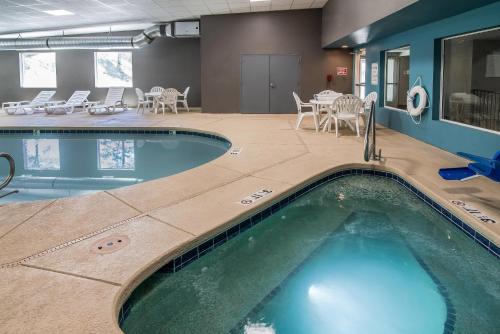 a pool in a hotel room with chairs and tables at Elevate Hotel at Sierra Blanca Ruidoso, an Ascend Collection Hotel in Ruidoso
