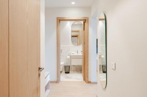 a bathroom with a mirror and a sink at Brassbell l Sheikh Zayed l Aeon Towers in Cairo