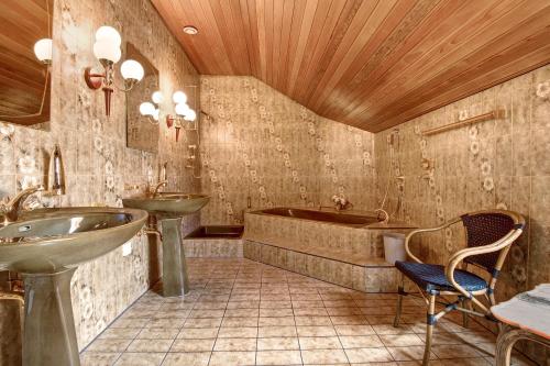 Un baño con bañera, lavabo y bañera. en Villa Galerie, en Hohenwart