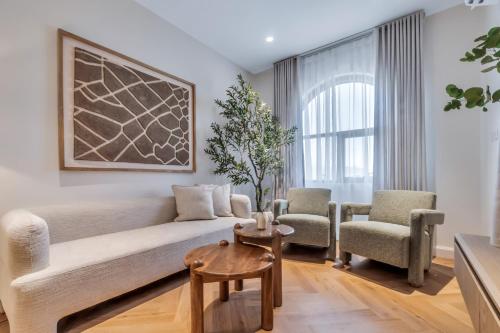 a living room with a couch and two chairs at Riviera Family Suite in Khor Fakkan