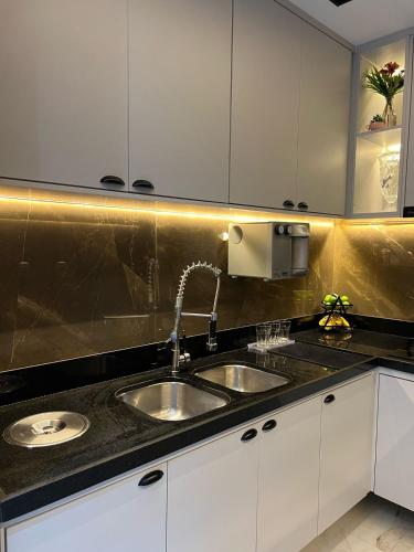 a kitchen with two sinks and white cabinets at Beautiful Apartment cop30 in Belém