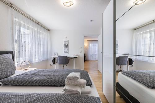 a bedroom with two beds and a mirror at Apartment Dußlingen in Dußlingen
