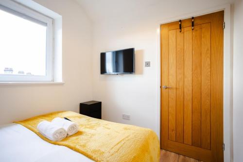 ein Schlafzimmer mit einem Bett und einem TV an der Wand in der Unterkunft Modern 1-BR Apartment near Cardiff City Centre in Cardiff