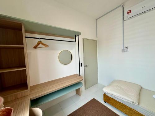 a small room with a bed and a mirror at Kuntum Homestay in Seri Iskandar