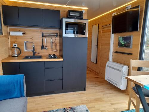 a small kitchen with a sink and a microwave at Hausboot Am See in Rieth