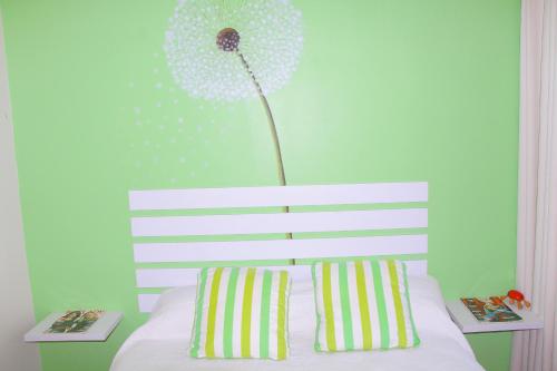 una camera da letto con un letto con un fiore sul muro di Keke's Place a Vila Praia Do Bilene