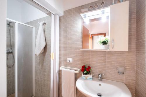 サン・フォカにあるOn The Beach San Focaの白い洗面台と鏡のあるバスルーム