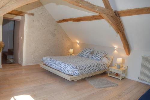 ein Schlafzimmer mit einem Bett in einem Zimmer mit Holzdecken in der Unterkunft Gîte de la Mésange in Saint-Nicolas-des-Motets