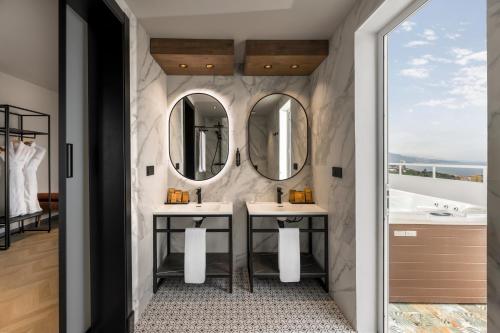a bathroom with two sinks and two mirrors at TUI BLUE Atlantic Hills in Puerto de la Cruz