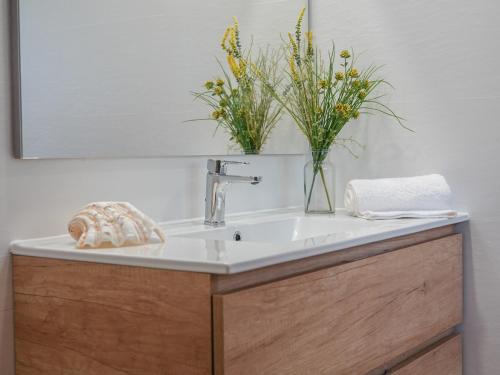 a bathroom sink with a vase of flowers on it at Vinyes Can Grau in Sencelles