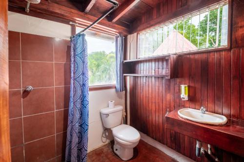 un baño con inodoro y lavabo en Hostel La Botella de Leche - Tamarindo, en Tamarindo