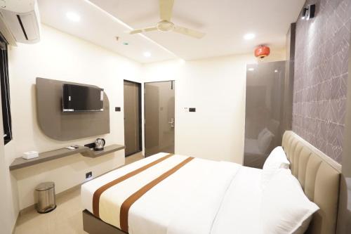 une chambre d'hôtel avec un lit et une télévision à écran plat dans l'établissement Hotel Akasa Residency Near T-2 International Airport Mumbai, à Mumbai
