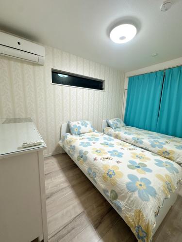 a small room with two beds and a kitchen at Kasilin House in Osaka
