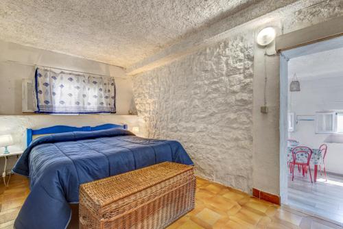 マルチャーナ・マリーナにあるCotetonda - Appartamento Ilviaのベッドと石の壁のある寝室