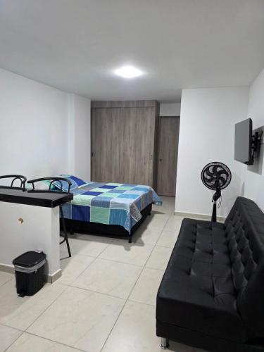 a bedroom with a bed and a couch in it at Apartaestudio 101 cómodo y Moderno in Tuluá