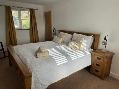 ein Schlafzimmer mit einem großen Bett mit einem Teddybär darauf in der Unterkunft Whitebridge Cottage in Swansea