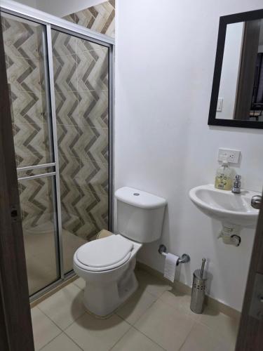 a bathroom with a toilet and a shower and a sink at Apartaestudio 101 cómodo y Moderno in Tuluá