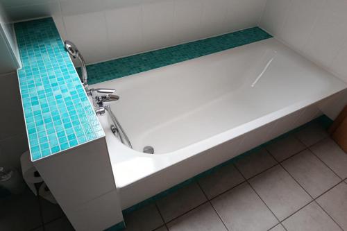 Klein GelmにあるDünenresidenz Glowe Dünenresidenz Glowe A 31の青いタイルの床の浴室にある浴槽