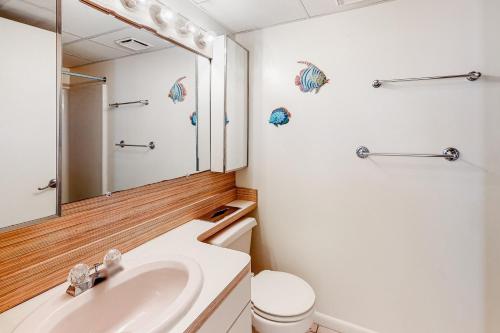 a bathroom with a sink and a toilet and a mirror at Waikiki #302 in Ocean City