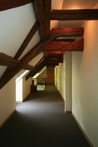 an attic hallway with wooden ceilings and a staircase at Depandance Vodoléčba in Lázně Libverda