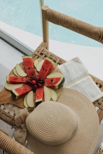 um prato de frutas e um chapéu em uma cadeira em Mykonos Pantheon em Kalo Livadi