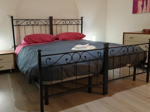 1 dormitorio con cama negra y almohadas rojas en La Casa dei Pioppi, en Ficarolo