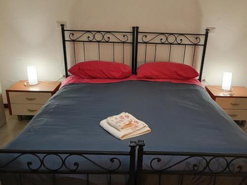 Una cama con dos almohadas rojas y una toalla encima. en La Casa dei Pioppi, en Ficarolo