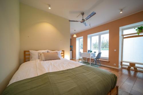 a bedroom with a large bed and a table at Charming Lahemaa national park Studio apartment for Nature Lovers in Kolga