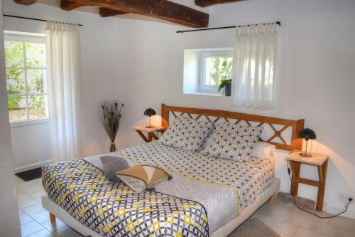 ein Schlafzimmer mit einem Bett und zwei Fenstern in der Unterkunft Domaine de la Picardière in Saint-Nicolas-des-Motets