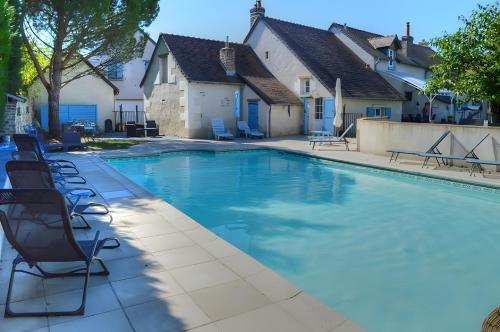 ein Swimmingpool mit Liegestühlen neben einem Haus in der Unterkunft Domaine de la Picardière in Saint-Nicolas-des-Motets