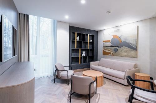 a living room with a couch and a table and chairs at SPA VILNIUS Druskininkai in Druskininkai
