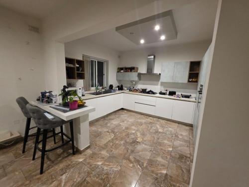 a kitchen with white cabinets and a table in it at Best In Town in Qormi