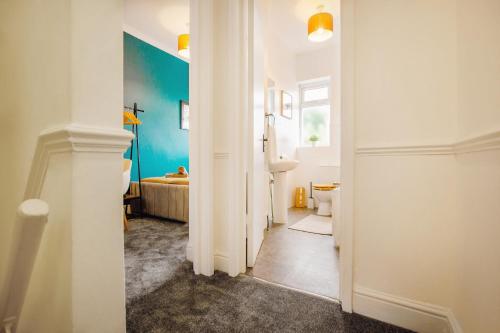 einen Flur mit einem Bad mit einem Waschbecken und einer Badewanne in der Unterkunft Blue Lagoon Retreat Escape Free Parking 14ppl in Sheffield