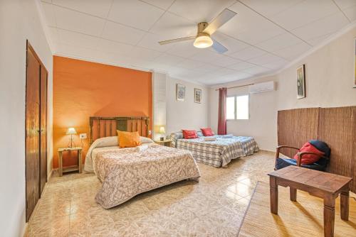 a hotel room with two beds and a couch at El Puente in Bolbaite