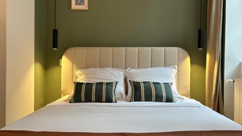 a bedroom with a bed with two pillows at Charlie Green in Nevers