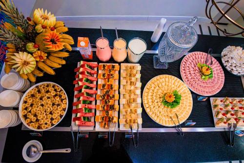 a table topped with plates of food and fruit at Hotel Sagres Praia in Balneário Camboriú