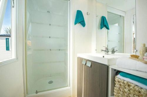 a bathroom with a shower and a sink at Camping Cœur de Vendée in La Boissière-de-Montaigu