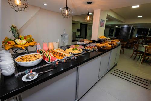 a buffet line with many different types of food at Hotel Sagres Praia in Balneário Camboriú