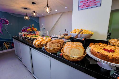a buffet with many different types of bread and pastries at Hotel Sagres Praia in Balneário Camboriú