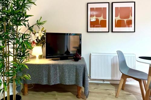 a television sitting on a table in a living room at 1 Bed - Sleeps 4 - Parking - 15 mins Gatwick in Crawley