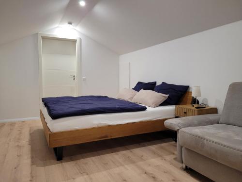 a bedroom with a bed and a couch at Beim Mooswiesler Dahoam in Polling